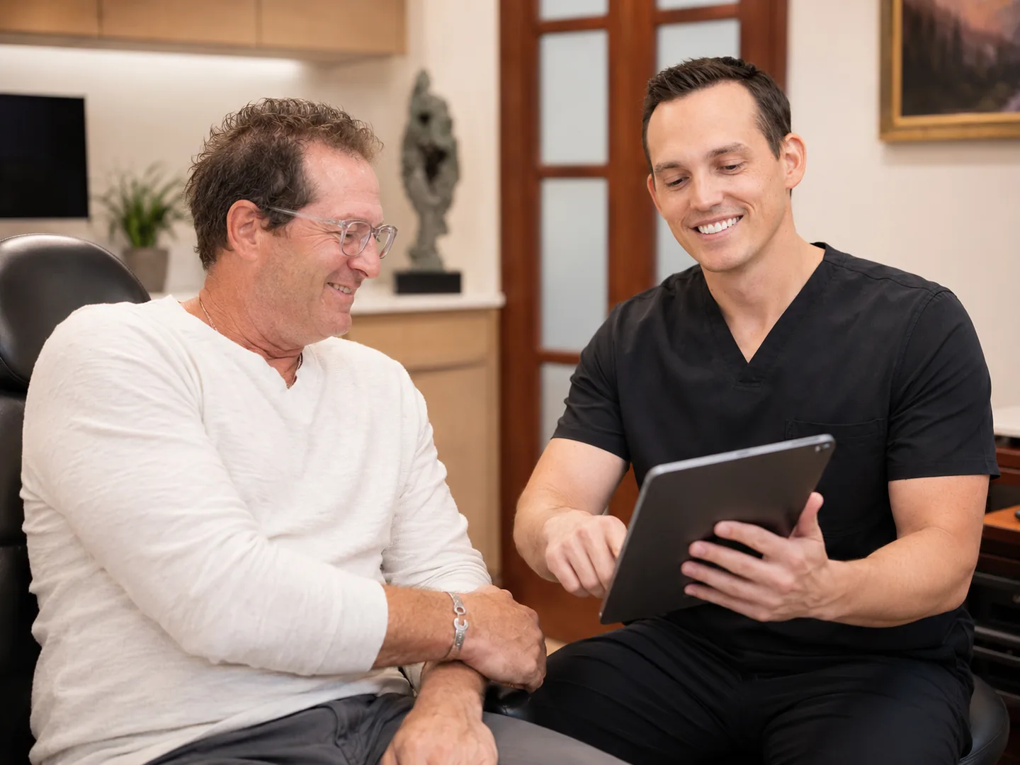 Dr. Kellen McWhorter, prosthodontist, reviewing a treatment plan with a patient at Christensen Prosthodontics in Orem, Utah
