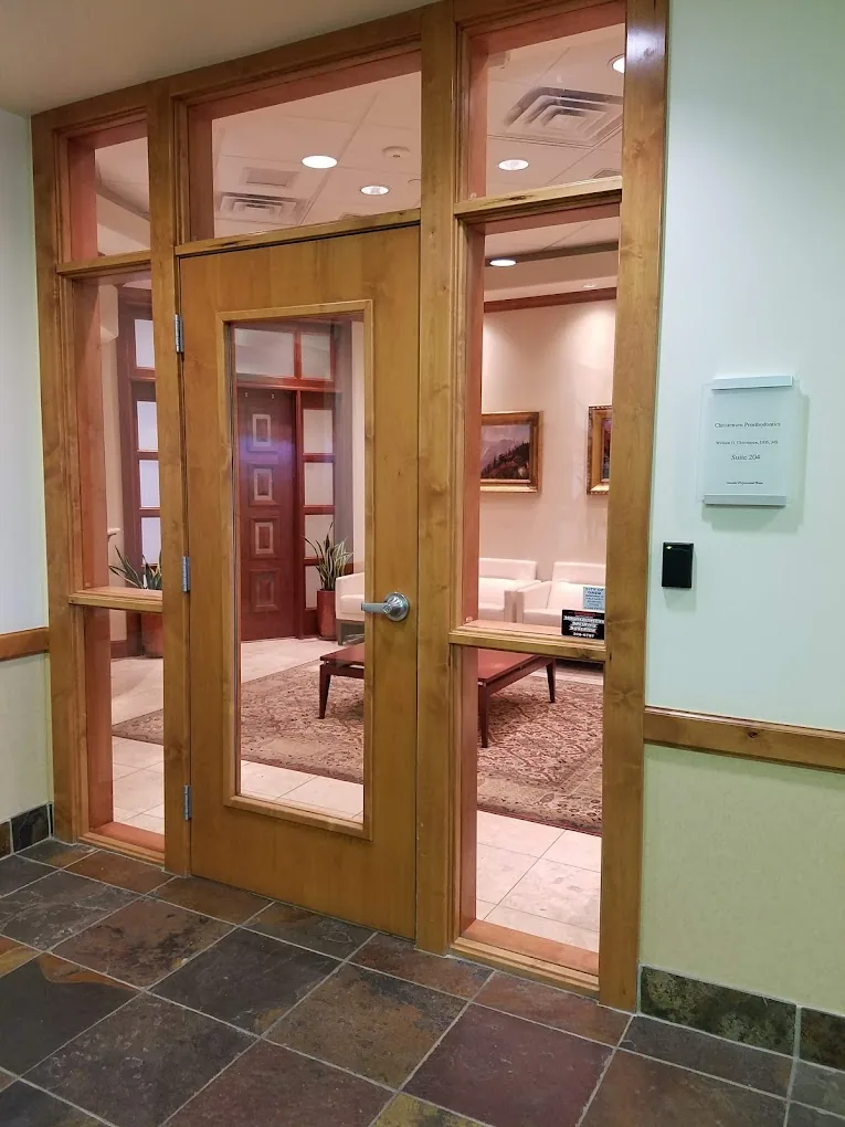 Glass entry door to Christensen Prosthodontics, Suite 204, with the waiting room visible inside
